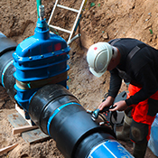 Man standing next to a big gate valve with PE ends